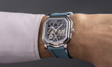 A wrist with a Gerald Charles Maestro watch with blue strap and exposed gears