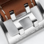 Close-up of the Hamilton Khaki Aviation X-Wind Auto Chrono’s brushed metal buckle, paired with a brown leather strap and white stitching—highlighting the precision craftsmanship of this automatic chronograph.