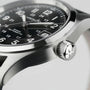 Close-up of the Hamilton Khaki Field Auto, a rugged, military-inspired watch with stainless steel case, black dial, white numerals, date window, and a textured crown featuring a star emblem.