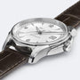 A close-up of the Hamilton Jazzmaster Viewmatic Auto shows its textured white dial, date window at 3 o’clock, silver case, and brown leather strap—showcasing modern craftsmanship from Hamilton.