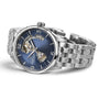 The Hamilton Jazzmaster Open Heart Auto showcases a blue dial, silver markers, and exposed Swiss automatic movement at an angle, paired with a stainless steel link bracelet.