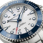 Close-up of the Hamilton Khaki Navy Scuba Auto wristwatch, featuring a white dial, blue ceramic bezel, luminous indices, and a stainless steel bracelet—an ideal summer accessory from Hamilton.
