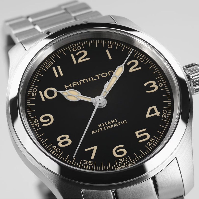 Close-up of the Hamilton Khaki Field Murph 38mm, featuring a black dial, luminous hands, Arabic numerals, and a stainless steel bracelet—a modern interpretation of this classic timepiece.