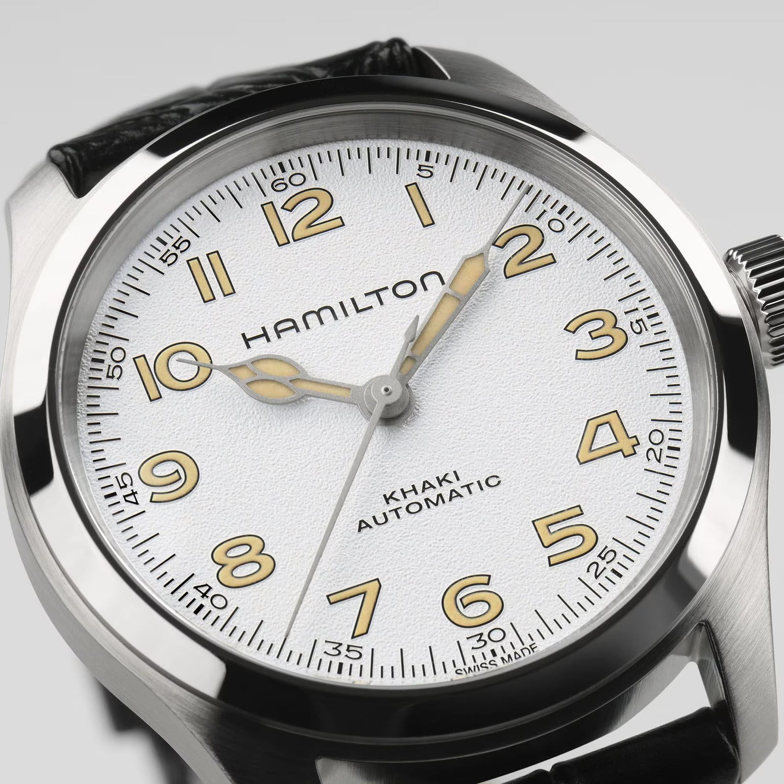 Close-up of the Hamilton Khaki Field Murph 38mm, featuring a white textured dial, gold-tone numerals and hands, and a black leather strap—a must-have vintage-inspired piece for Hamilton fans.
