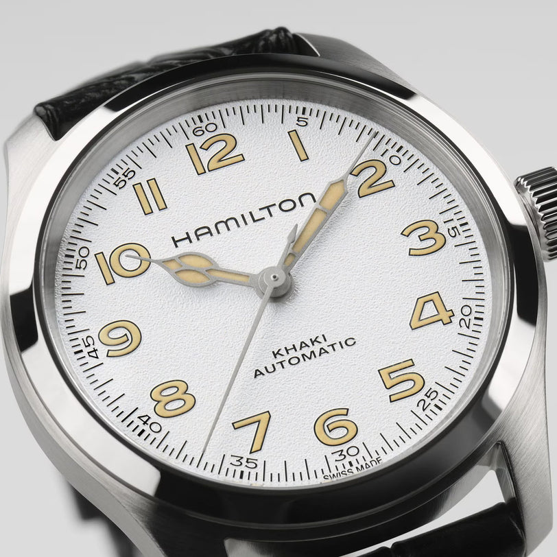 Close-up of the Hamilton Khaki Field Murph 38mm, featuring a white textured dial, gold-tone numerals and hands, and a black leather strap—a must-have vintage-inspired piece for Hamilton fans.