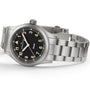 Hamilton Khaki Field Quartz 38mm wristwatch with a black dial, cream numerals, and a metal link band, shown at an angle.