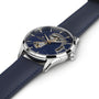 A close-up of the Hamilton Jazzmaster Open Heart Auto 42mm dress watch featuring a navy blue leather strap, silver case, and partially open-worked blue dial that reveals its automatic movement.