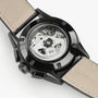 Close-up of the Hamilton Jazzmaster Performer Autochrono 42mm, showcasing its automatic movement through a transparent case back and beige leather straps, with chronograph counters reflected in the design.