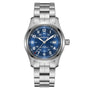 The Hamilton Khaki Field Auto 42mm is a stainless steel watch with a blue dial, white numerals, H-10 automatic movement, date at 3 o’clock, and metal bracelet. Hamilton’s military heritage appears below 12 o’clock.