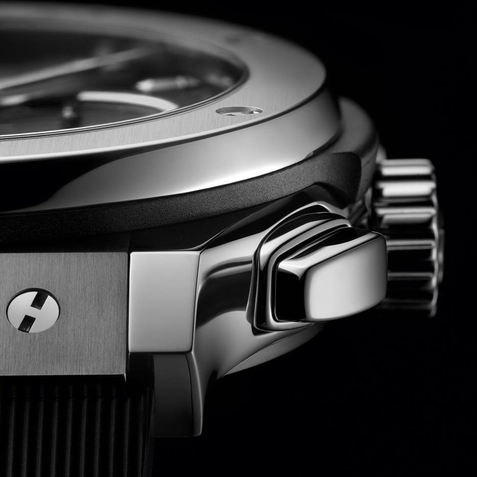 Close-up of the Hublot Classic Fusion Chronograph Titanium, highlighting its polished titanium case, crown, and pushers, with part of the self-winding chronograph dial and strap in view.