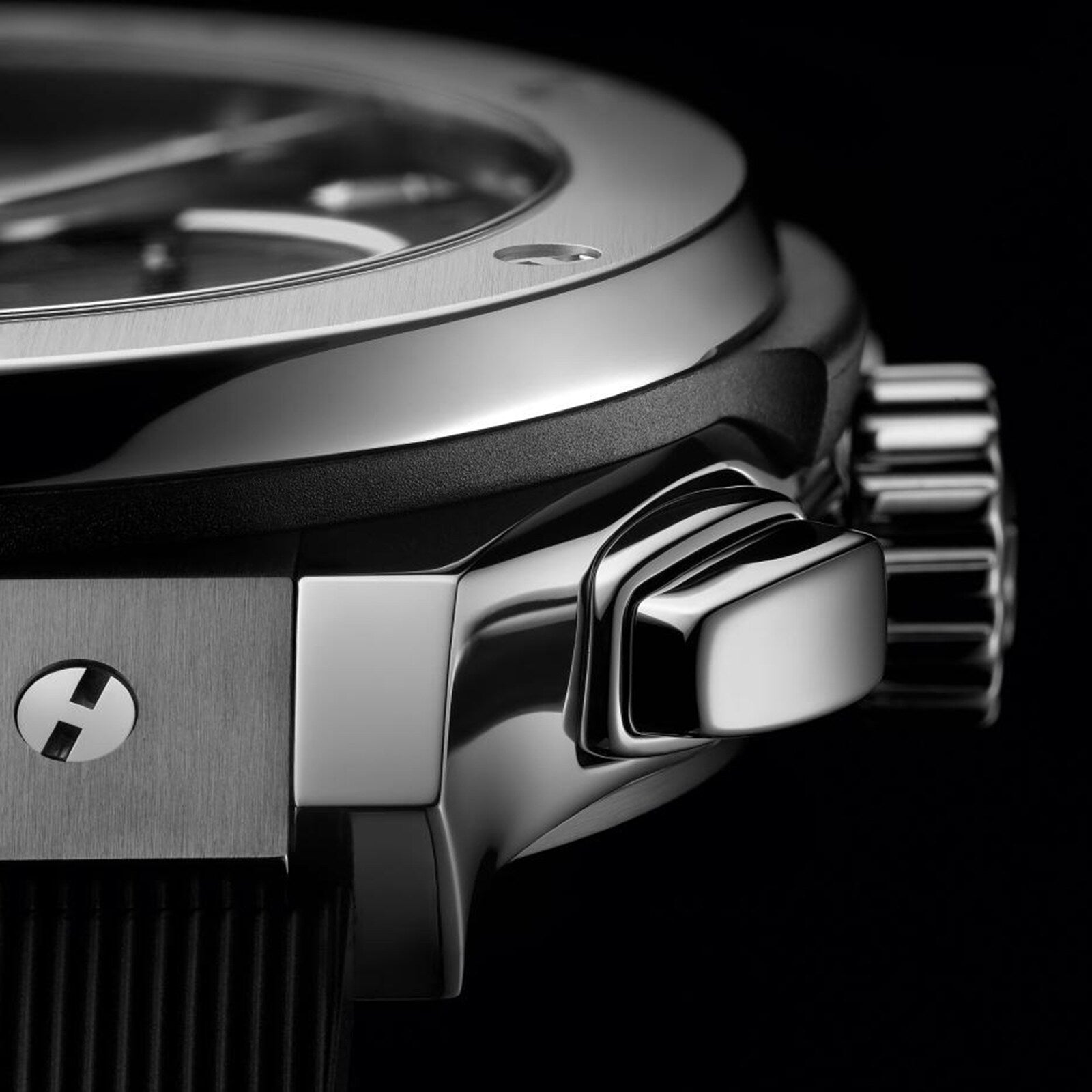 Close-up of the Hublot Classic Fusion Chronograph Titanium, highlighting its polished titanium case, crown, and pushers, with part of the self-winding chronograph dial and strap in view.