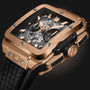 A close-up of the Hublot Square Bang Unico King Gold, featuring an 18K King Gold rectangular case, exposed Unico 2 calibre movement, black accents, and a black textured strap.