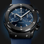 Close-up of a Hublot Classic Fusion Ceramic Blue Chronograph featuring a blue sunray dial with three subdials, date window, and blue strap. The watch has a brushed ceramic bezel with exposed screws.