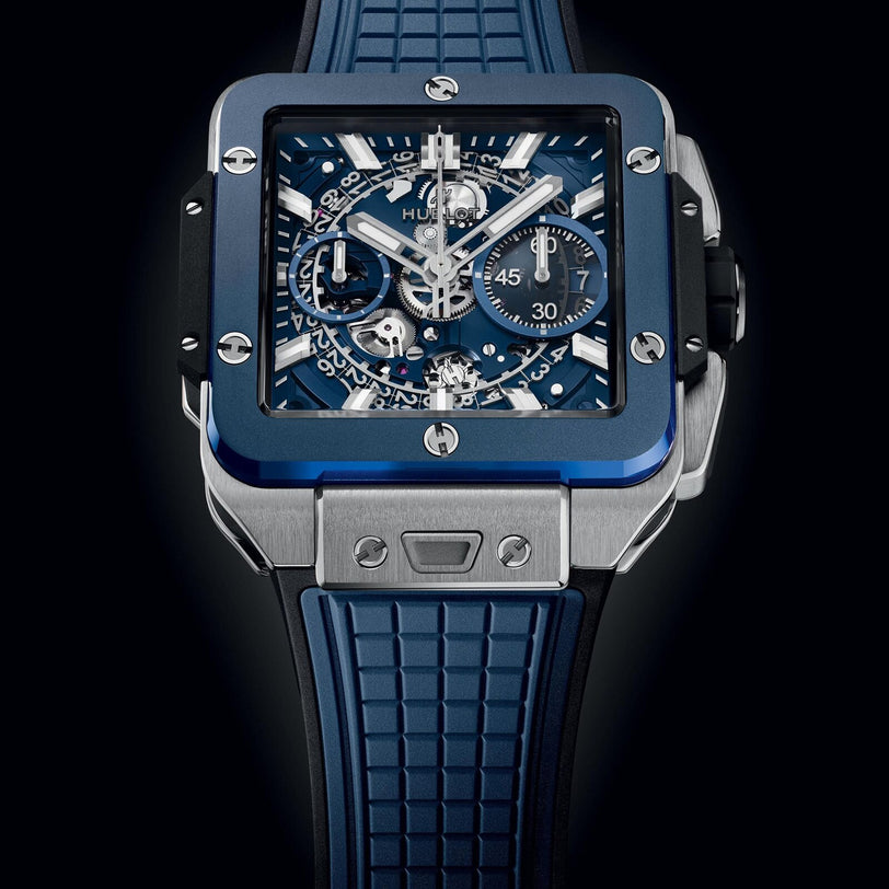 The Hublot Square Bang Unico Titanium Blue Ceramic features a skeleton sapphire dial, HUB1280 UNICO chronograph movement, and a blue textured rubber strap.