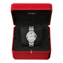 A Ballon Bleu de Cartier wristwatch by Cartier, featuring a round silver face and sapphire cabochon crown, shown in an open red Cartier box with black velvet lining.