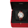 A Cartier Ballon Bleu de Cartier wristwatch with a pink gold case, brown leather strap, and Roman numeral guilloché dial is shown in an open red Cartier box.