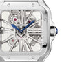 Close-up of the Cartier Santos de Cartier Skeleton watch, featuring a square stainless steel case, blue hands, visible gears, and precise mechanical movement.