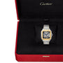 A Santos de Cartier Skeleton watch by Cartier, featuring a mechanical movement and metal bracelet, is displayed in an open red Cartier box with a black velvet interior.