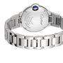 A close-up of the back of the Cartier Ballon Bleu de Cartier watch highlights its engraved details, stainless steel finish, blue cabochon crown, and self-winding movement.
