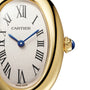 Close-up of a Cartier Baignoire gold watch with blue hands, Roman numerals, and a sapphire crown.