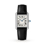 The Cartier Tank Must de Cartier watch features a rectangular white dial with black Roman numerals, blue hands, and a black leather strap. This quartz timepiece is shown on a plain white background.