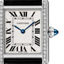 Close-up of the Cartier Tank Must de Cartier watch face, featuring Roman numerals, blue sword-shaped hands, a diamond bezel, steel case, and a crown set with a blue cabochon.