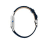 Side view of the Cartier Santos-Dumont watch, featuring a blue leather strap, silver case, and blue gemstone crown, shown against a white background.