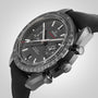 A close-up of the OMEGA Speedmaster Dark Side of The Moon Ceramic shows its black ceramic case, tachymeter bezel, chronograph subdials, and textured strap, highlighting the watch’s Lunar Legacy against a plain background.