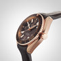 An angled side view close-up of the OMEGA Seamaster Planet Ocean 600M, featuring a black dial, gold case, and black leather strap.