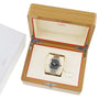 An OMEGA Seamaster Planet Ocean 600M watch is shown inside an open wooden OMEGA box with a cream interior and red trim, placed next to a white box featuring the OMEGA logo.