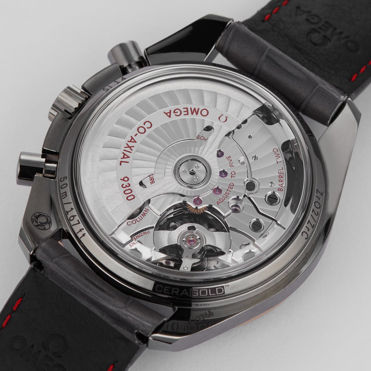 Close-up of the transparent case back on the OMEGA Speedmaster Dark Side of the Moon Meteorite, showcasing its ceramic case and revealing the intricate mechanical movement with engraved details.
