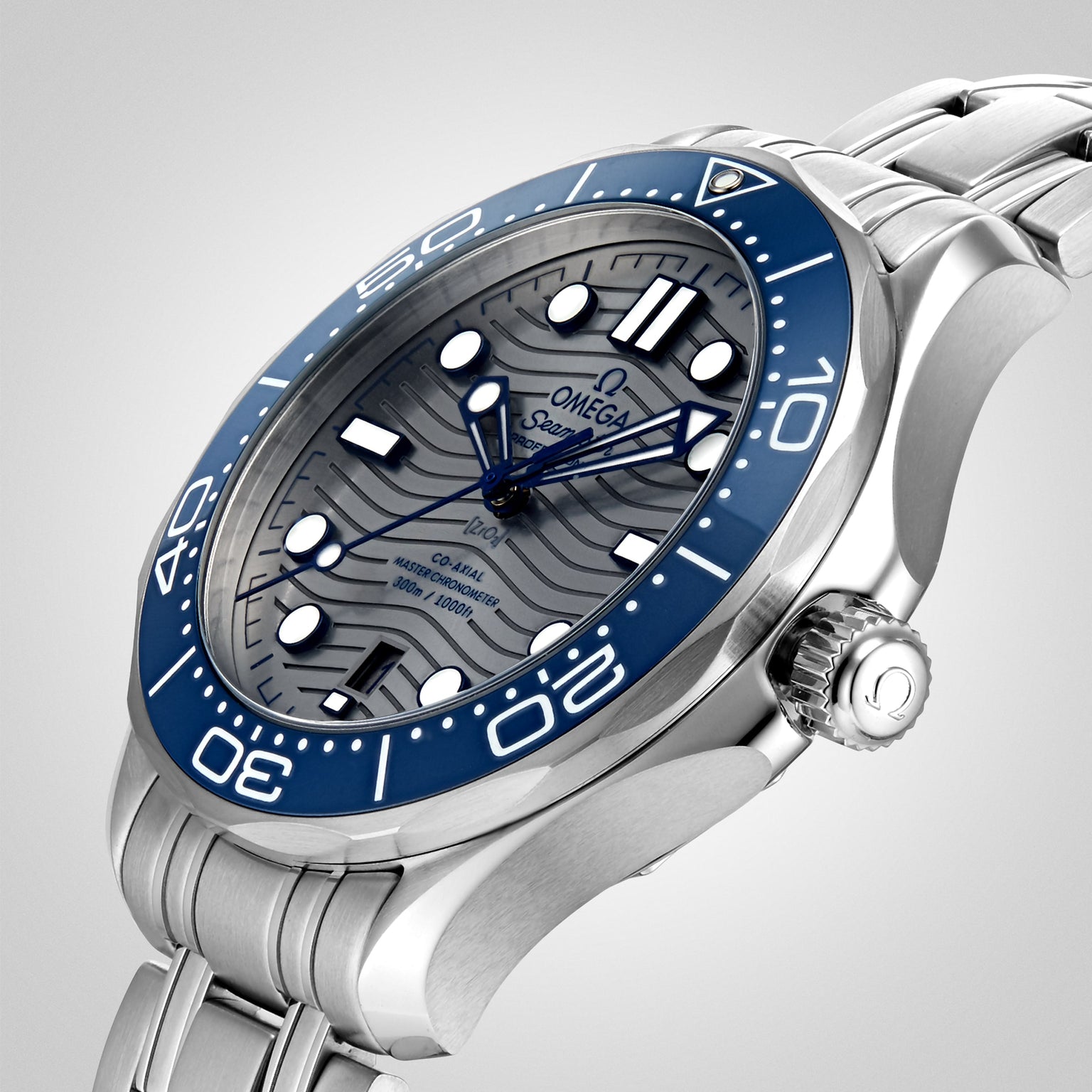 A close-up of the OMEGA Seamaster Diver 300M featuring a blue ceramic bezel, wavy dial, stainless steel bracelet, and powered by the OMEGA Calibre 8800.