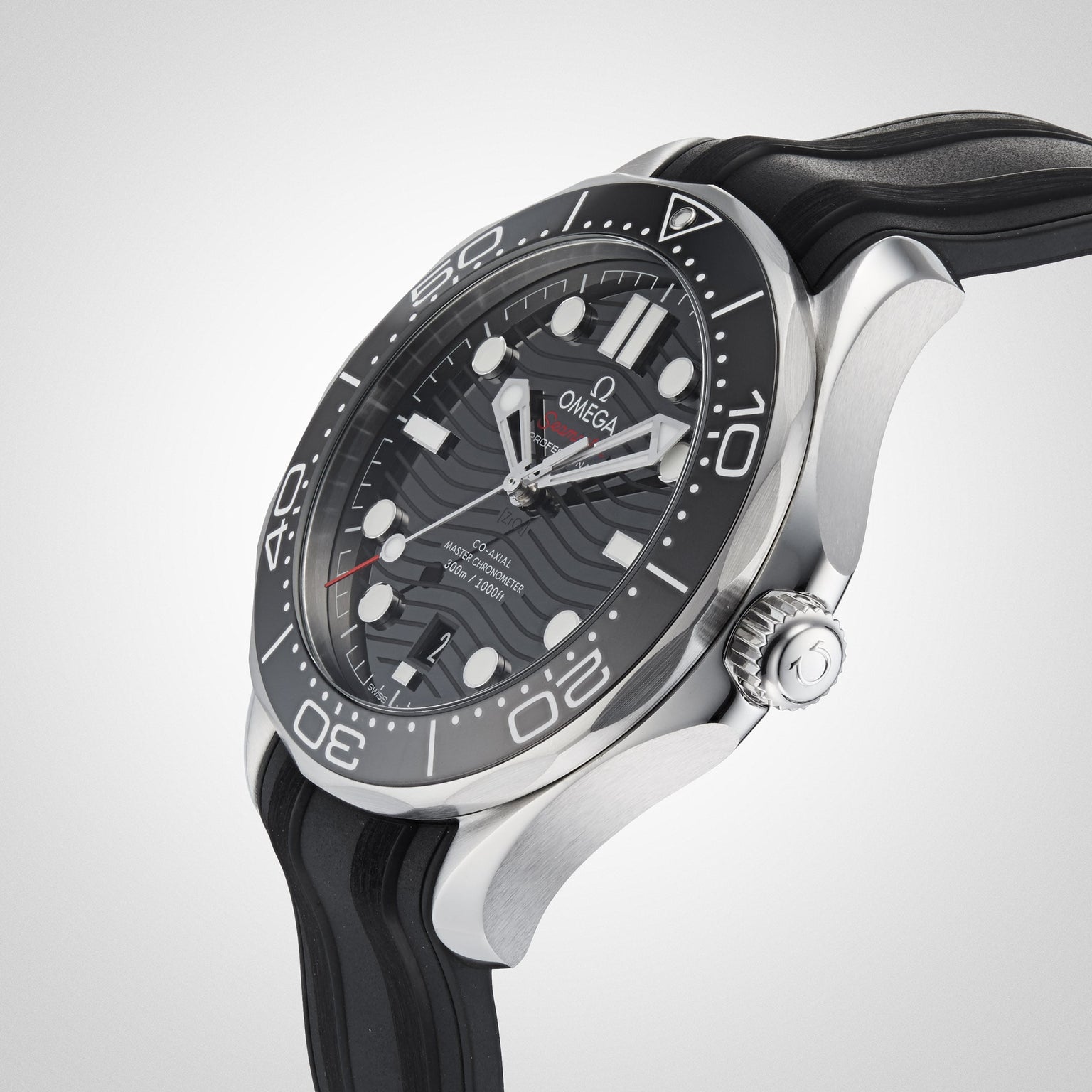 A close-up of the OMEGA Seamaster Diver 300M, featuring a black dial with wave pattern, bold hour markers, and a black rubber strap set against a light background.