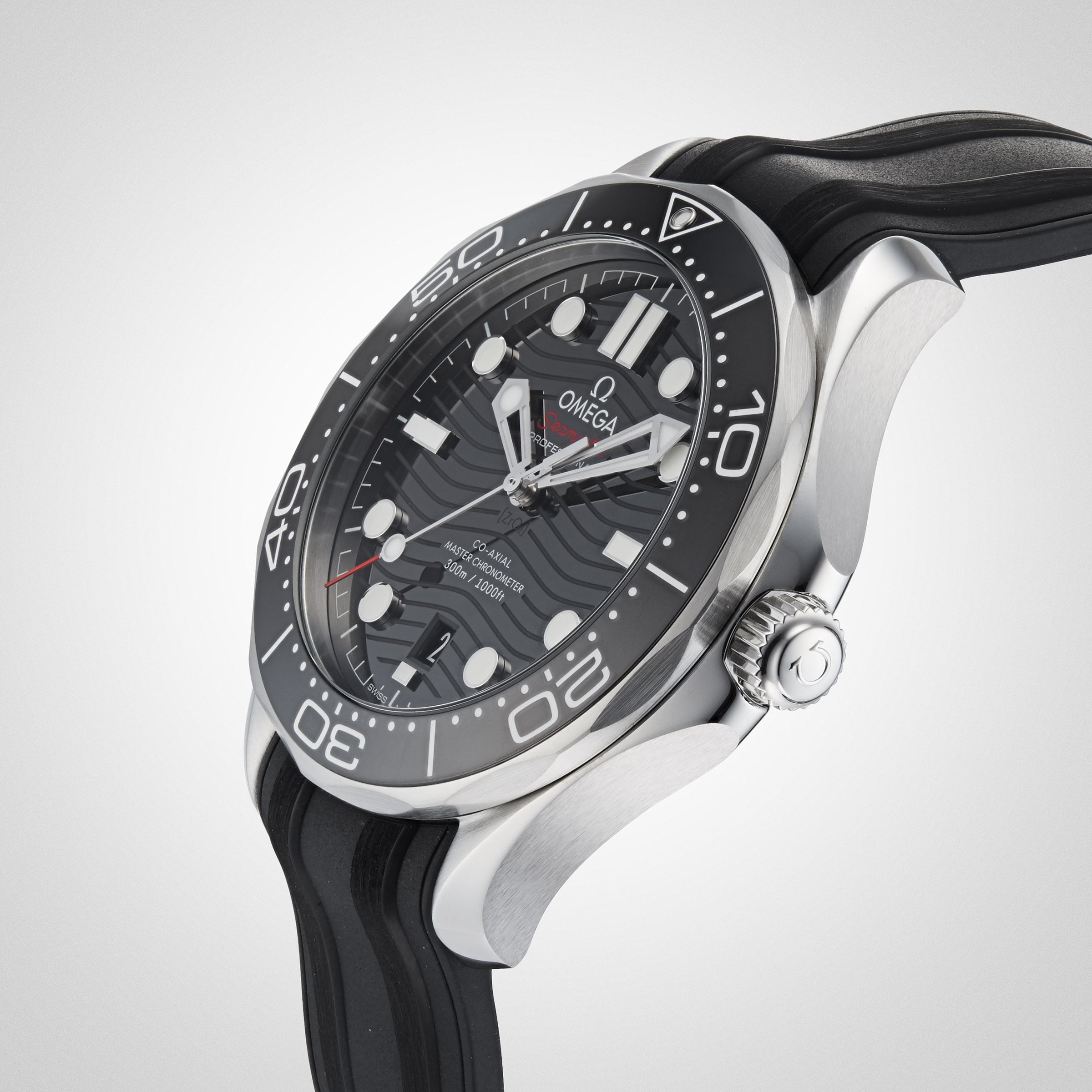 A close-up of the OMEGA Seamaster Diver 300M, featuring a black dial with wave pattern, bold hour markers, and a black rubber strap set against a light background.