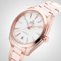 The OMEGA Seamaster Aqua Terra 150M wristwatch in 18K Sedna™ gold features a white dial, gold hour markers, a date display at 6 o’clock, and is shown on a matching metal bracelet.