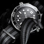 Close-up of the OMEGA Seamaster Diver 300M with a black and grey NATO strap, black dial, white markers, and rotating bezel—a true Master Chronometer dive watch by OMEGA.