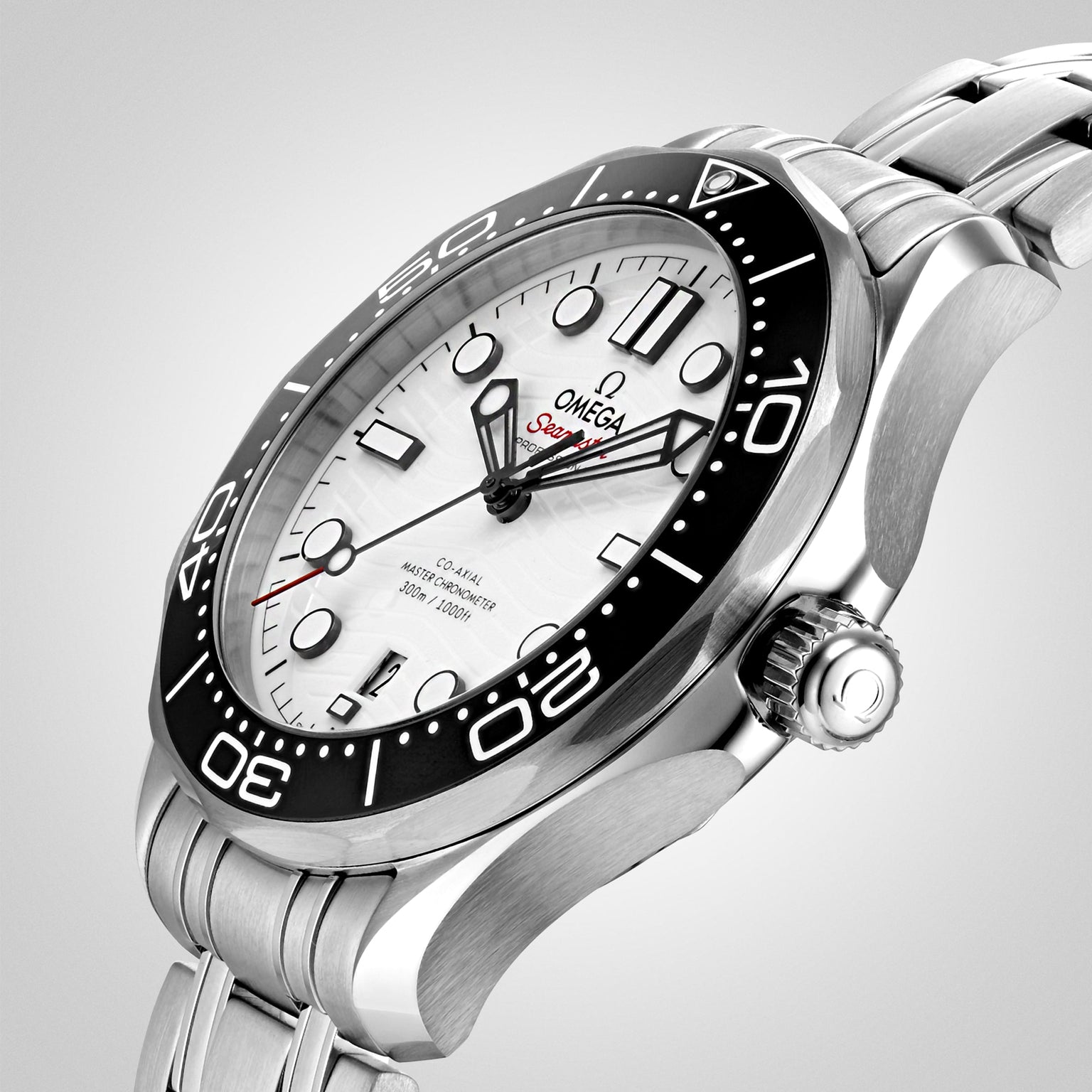 A close-up of the OMEGA Seamaster Diver 300M wristwatch with a stainless steel band, white dial, black bezel, and red Seamaster text on the face—a true Bond watch and METAS-certified.