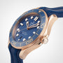 A close-up of the OMEGA Seamaster Diver 300M, featuring a blue dial, gold case, and blue rubber strap—an iconic dive watch famously associated with James Bond.