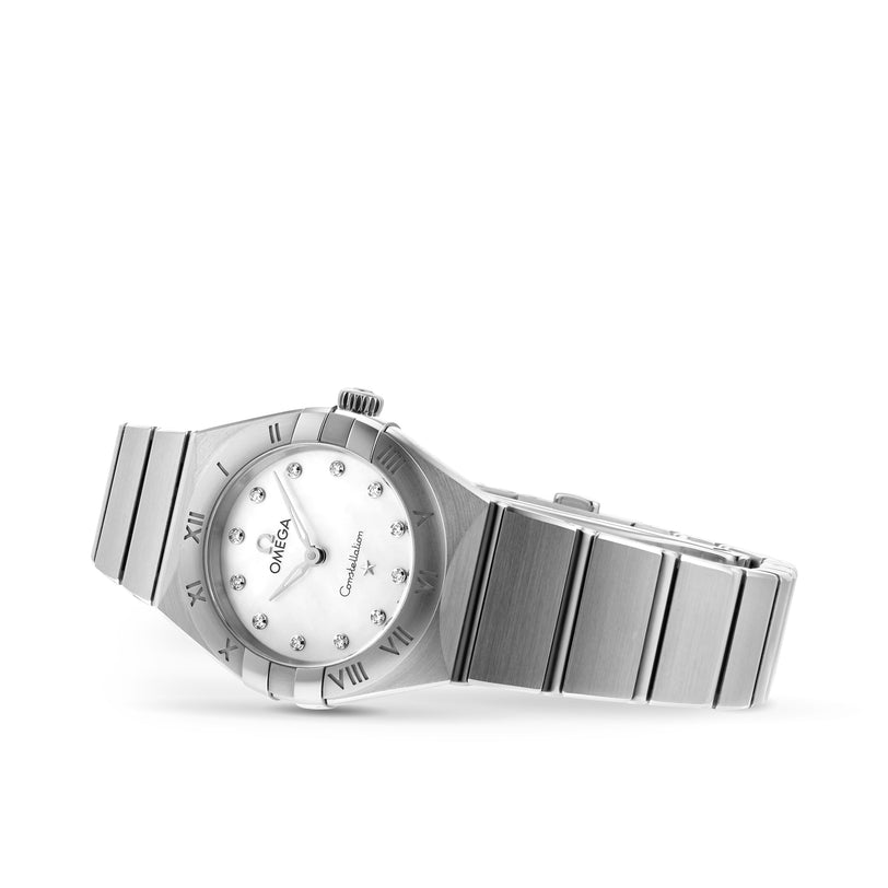 The OMEGA Constellation features a 28mm stainless steel case, white dial with diamond hour markers, and Roman numerals on the bezel, shown at an angle.