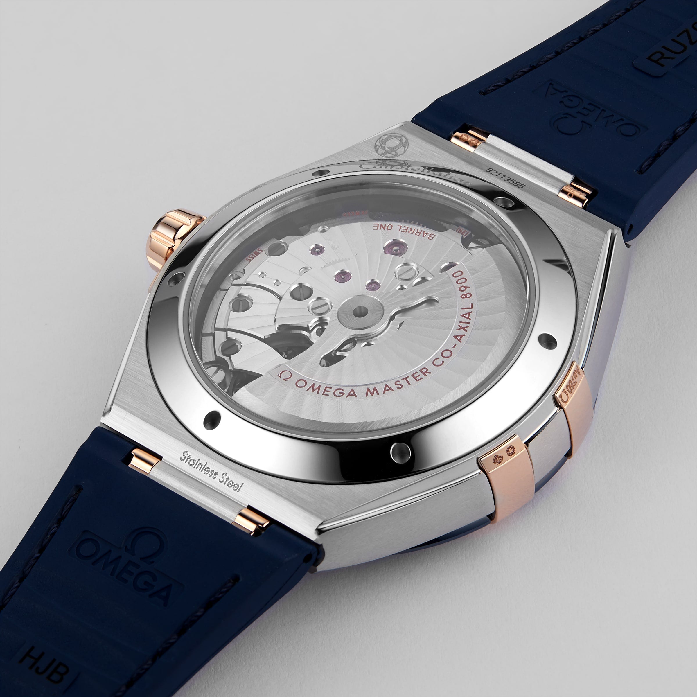 Close-up of the back of the OMEGA Constellation watch with a blue strap, highlighting its exposed 8900 calibre movement and engraved case. This Master Chronometer certified timepiece reflects OMEGAs renowned precision and Constellation heritage.
