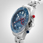 Close-up of an OMEGA Seamaster Diver 300M Americas Cup Edition, featuring a stainless steel case, blue dial, white markers, red and blue pushers, and a metal bracelet set against a light gradient background.
