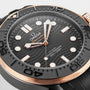Close-up of the OMEGA Seamaster Diver 300M featuring a black wavy dial, gold accents, bold hour markers, and a numbered black bezel. Powered by the precise OMEGA Calibre 8806 and inspired by the iconic James Bond watch.