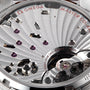 Close-up of an OMEGA Speedmaster Chronoscope movement highlighting intricate gears, jewels, and engraved text such as MASTER CO-AXIAL, FORTY-FOUR (44) JEWELS, and SWISS.
