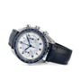 The OMEGA Speedmaster Chronoscope is a silver chronograph wristwatch with a white dial, blue Arabic numerals and hands, and a blue leather strap, shown at an angle on a white background with 1940s-inspired details.