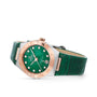 OMEGA’s Constellation watch features a green dial, matching strap, diamond hour markers, and a two-tone bezel in 18K Sedna™ gold and silver, elegantly showcased at an angle.