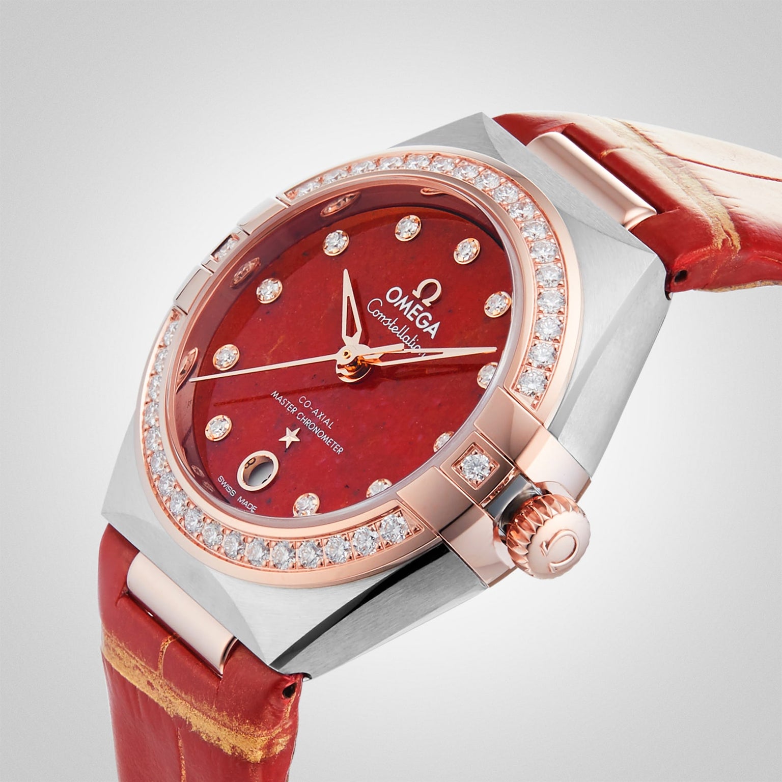 The OMEGA Constellation is a luxury watch with a red dial, diamond hour markers, rose gold bezel, and red leather strap, Master Chronometer certified for precision, displayed against a plain background.