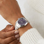 A person wearing an OMEGA Seamaster Aqua Terra 150M with a dark purple dial and a white knitted sweater, capturing timeless maritime heritage.