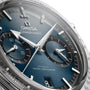 Close-up of the OMEGA Speedmaster 57 wristwatch, showcasing a blue dial with two subdials, silver hour markers, and calibre 9906.