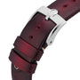 Close-up of a burgundy leather strap with a silver buckle featuring the OMEGA logo, designed for the iconic Speedmaster 57 chronograph.
