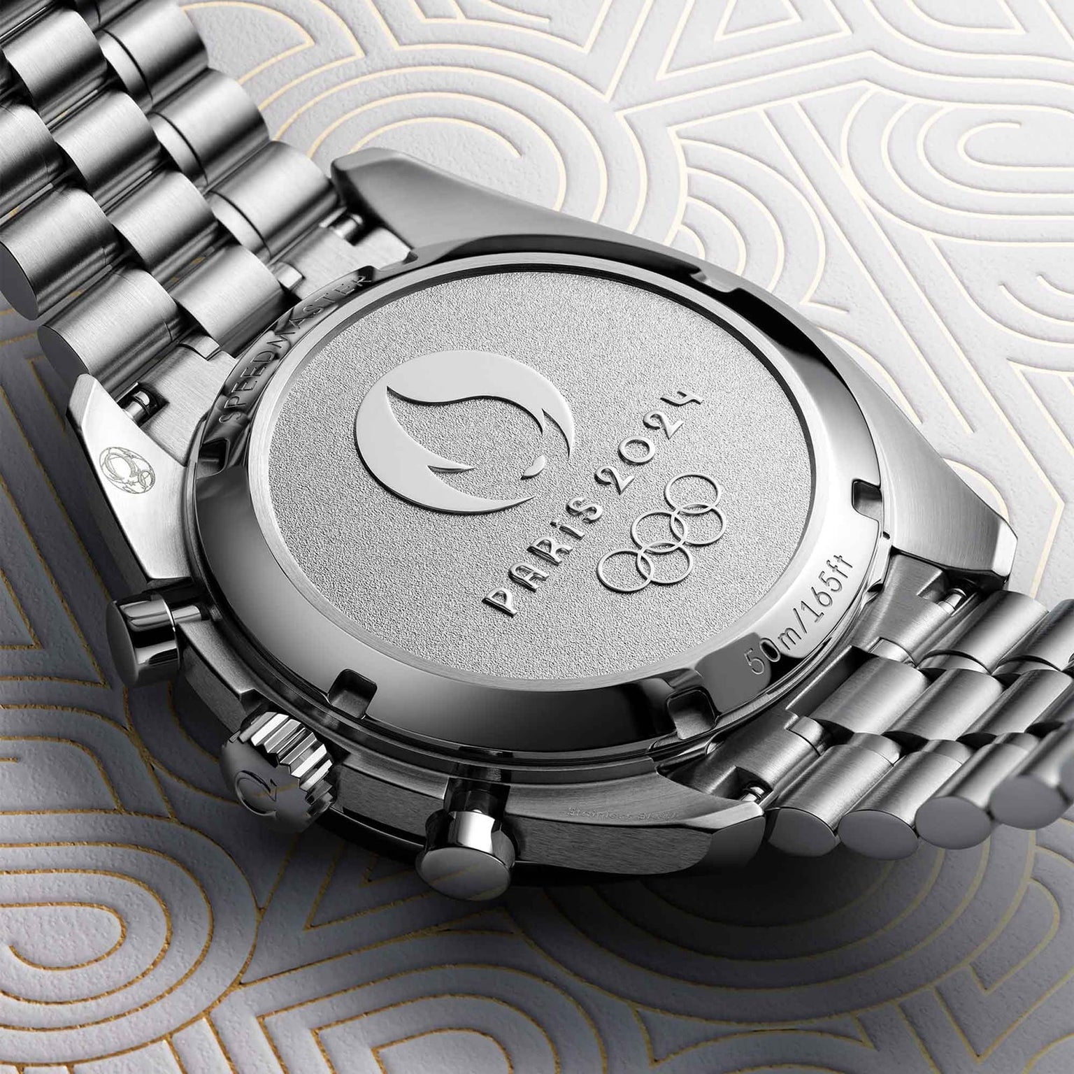 Close-up of the back of the OMEGA Speedmaster Chronoscope Paris 2024 Olympics, featuring engravings of the Paris 2024 logo, Olympic rings, and a 50m/165ft water resistance marking.